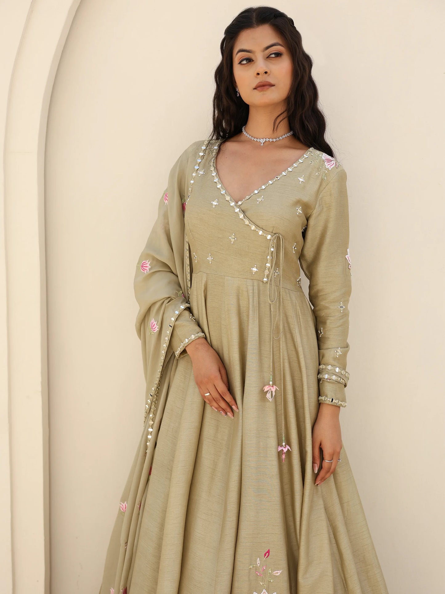Woman wearing a sage green anarkali with mirror work