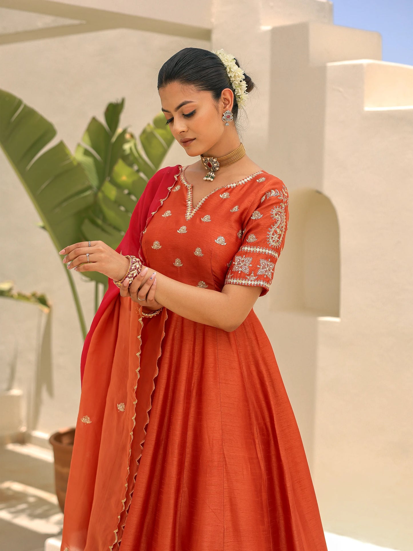 Close-up of a model dressed in a crimson flame ombre Anarkali with a shaded dupatta.