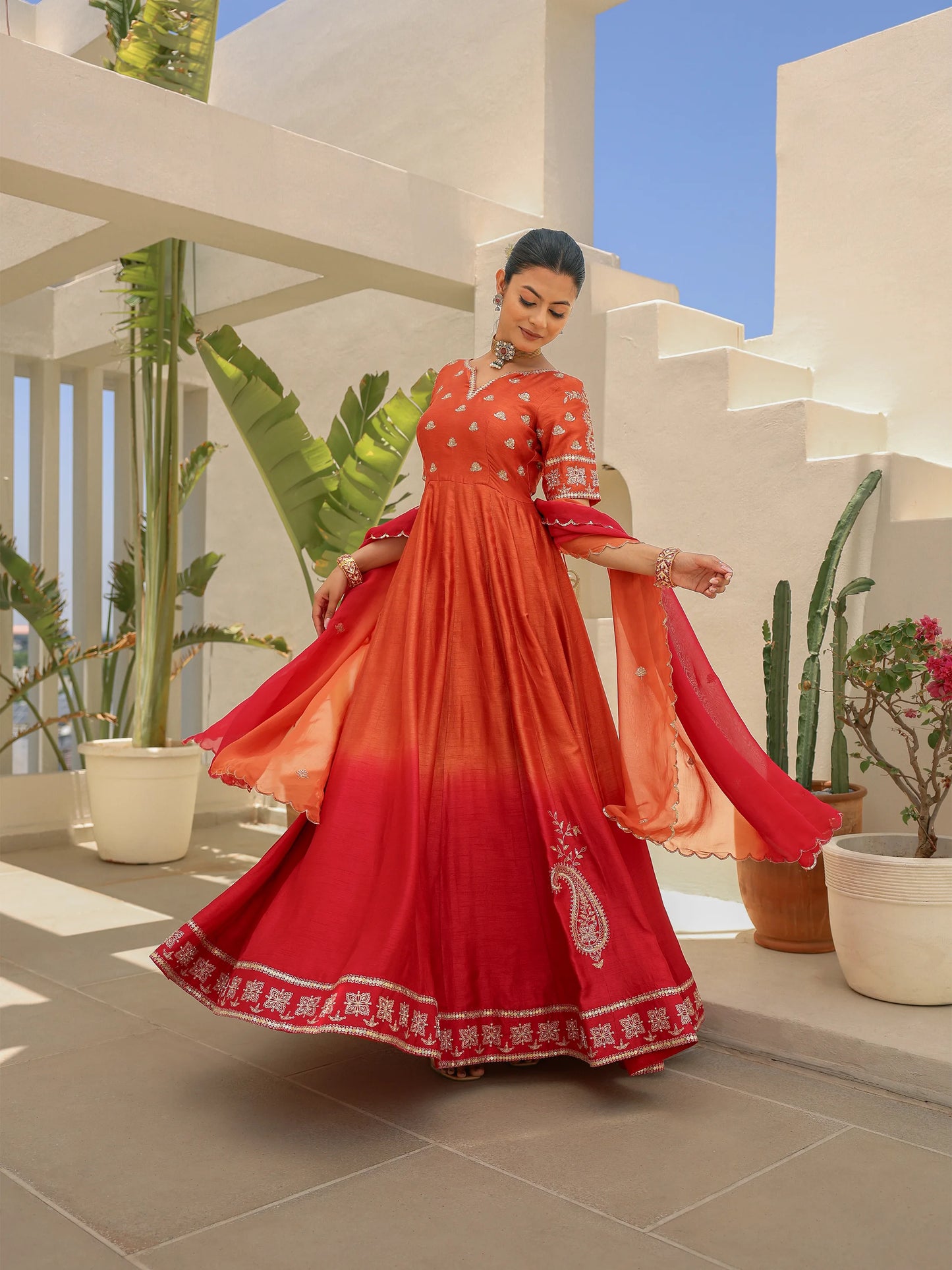 Model twirling in a rustic orange ombre Anarkali styled with a shaded dupatta.