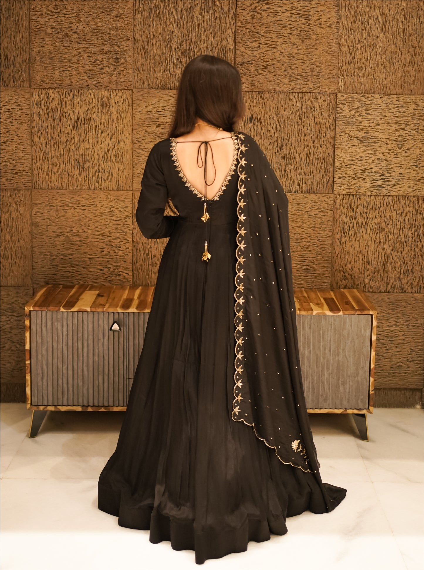 black anarkali suit with golden embroidered borders.