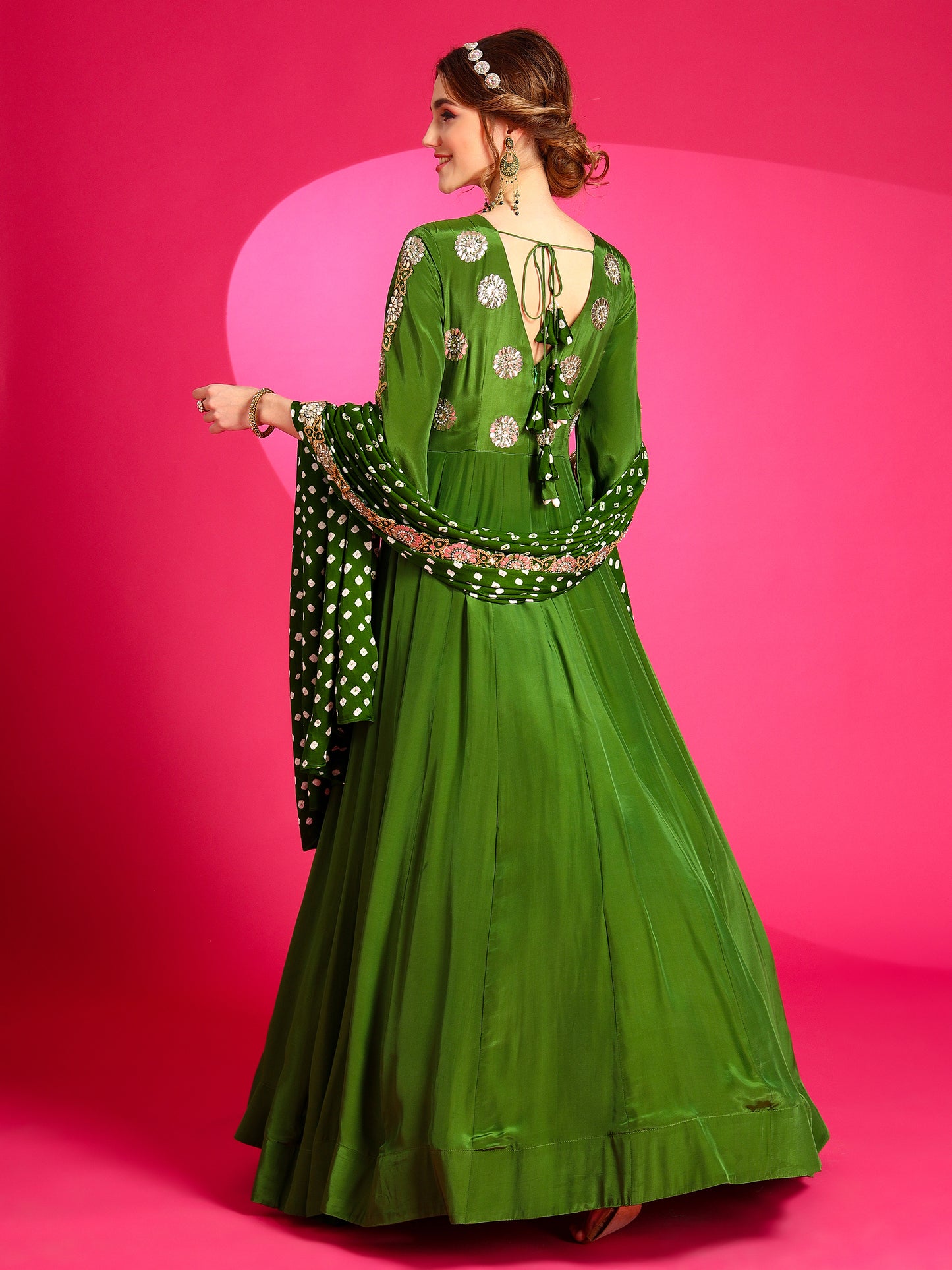 A model wearing a beautiful green colored back v-neck gown.