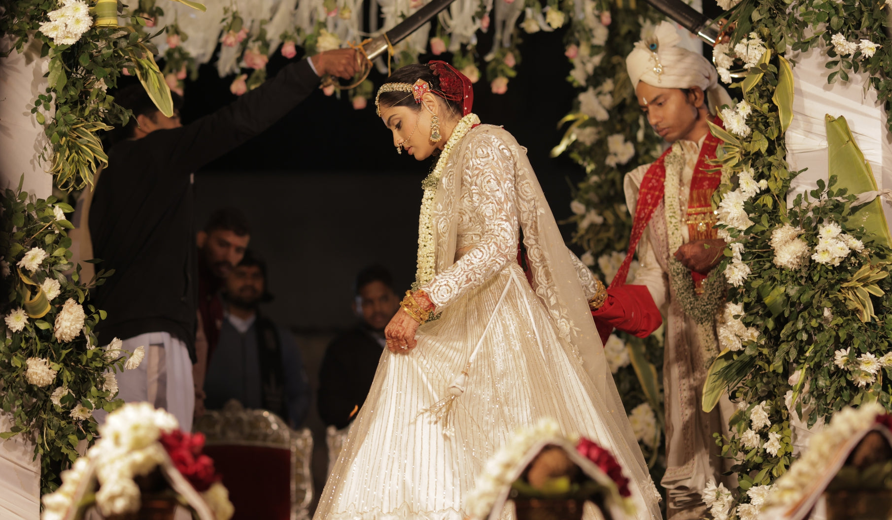 Bride wearing a white lehenga set with red veil for pheras, Buy this lehenga for your phera or wedding ceremonies.